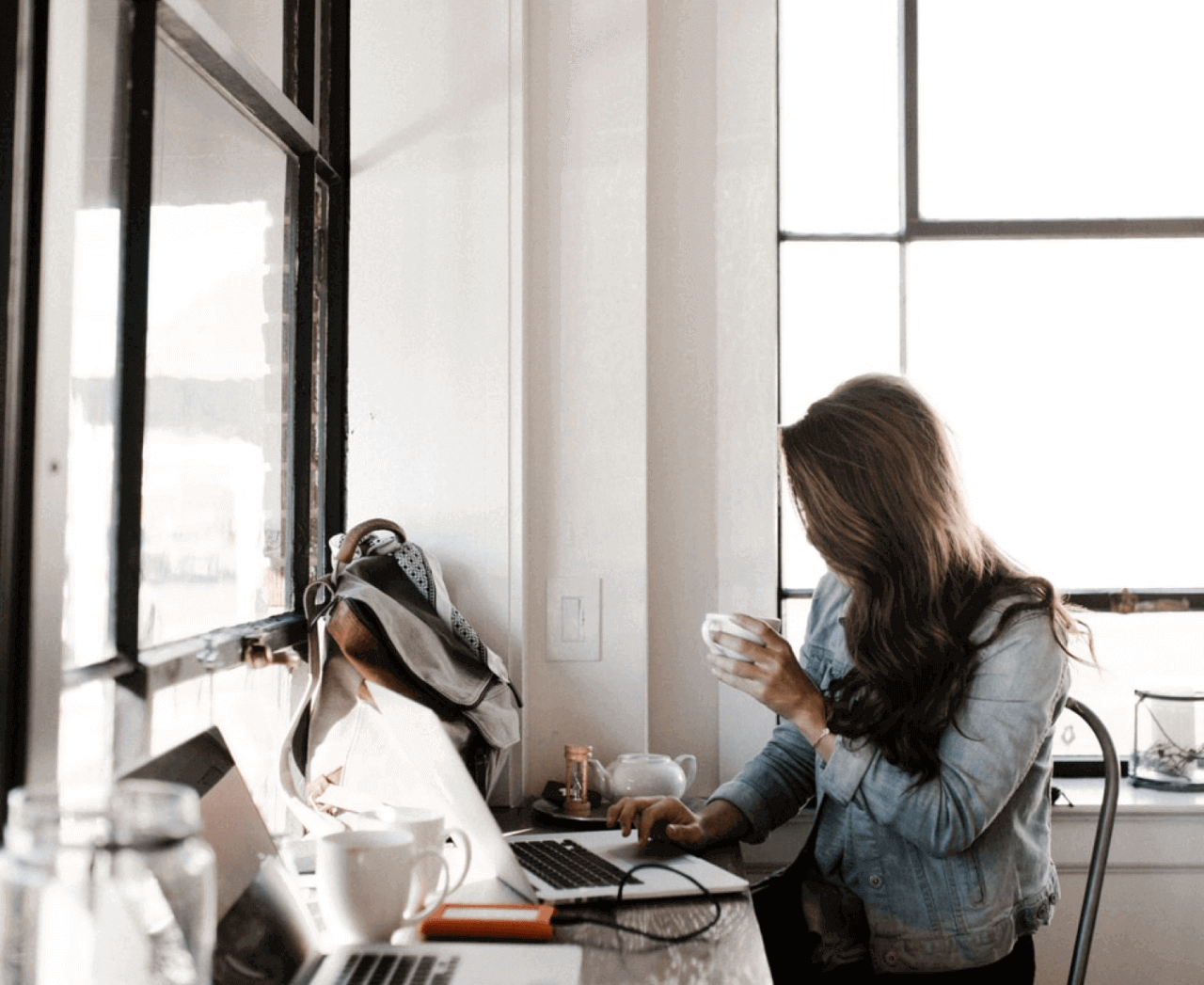 Kvinna skickar e post på ett kafé medans hon dricker kaffe